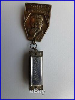 Very rare vintage brass Hohner Harmonica badge with miniature harmonica