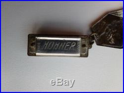 Very rare vintage brass Hohner Harmonica badge with miniature harmonica